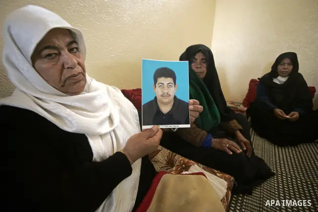 A Palestinian relative of Hasan Abu Mustafa holds his picture in his home in Khan Younis in the southern Gaza Strip on February 26, 2011. Pro-Gaddafi gunmen shot and killed Palestinian student Hasan Abu Mustafa outside h...