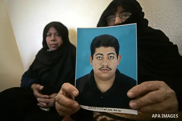 A Palestinian relative of Hasan Abu Mustafa holds his picture in his home in Khan Younis in the southern Gaza Strip on February 26, 2011. Pro-Gaddafi gunmen shot and killed Palestinian student Hasan Abu Mustafa outside h...