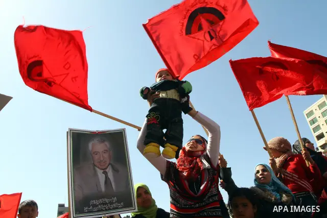 A Palestinian supporter of the Democratic Front for the Liberation of Palestine (DFLP) hold her baby during a rally celebrating 42 years since its founding in Gaza City, Saturday, Feb. 26, 2011. Founded in 1969 the DFLP...