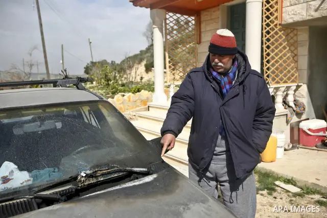 A Palestinian man Bashir Zabin inspects the remains of fire sparked by Israeli settlers at the yard of his home in the West Bank village of Burin, near Nablus, Saturday , Feb. 26, 2011. Photo by Wagdi Eshtayah