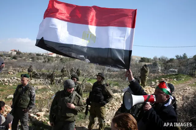Israeli soldiers stand guard during a demonstration by Palestinian, Israeli and foreign activists against the demolishing of farm land to be used in the construction of Jewish settlements near the existing Israeli settle...