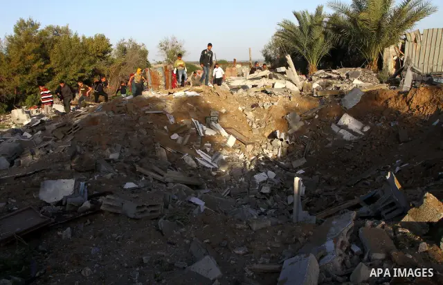 Palestinian onlookers gather at the scene of an Israeli air strike in the al-Burij refugee camp in the central Gaza Strip on February 26, 2011. Israeli warplanes bombed two training camps of the hardline Islamic Jihad gr...