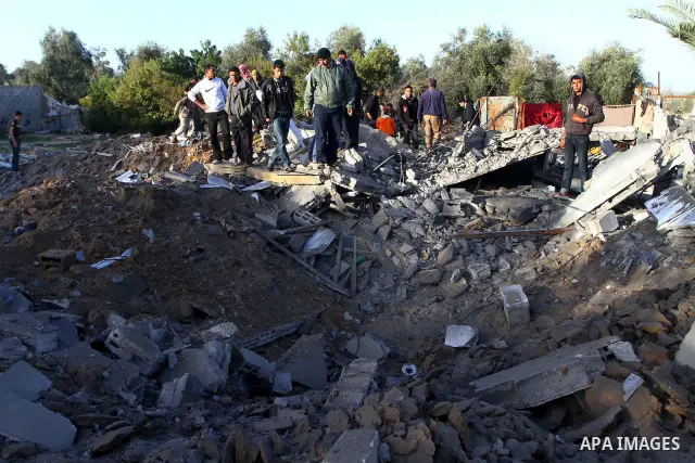 Palestinian onlookers gather at the scene of an Israeli air strike in the al-Burij refugee camp in the central Gaza Strip on February 26, 2011. Israeli warplanes bombed two training camps of the hardline Islamic Jihad gr...