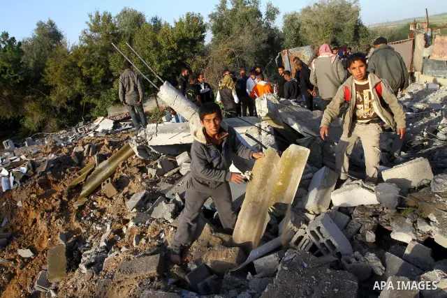 Palestinian onlookers gather at the scene of an Israeli air strike in the al-Burij refugee camp in the central Gaza Strip on February 26, 2011. Israeli warplanes bombed two training camps of the hardline Islamic Jihad gr...