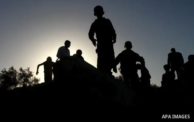 Palestinian onlookers gather at the scene of an Israeli air strike in the al-Burij refugee camp in the central Gaza Strip on February 26, 2011. Israeli warplanes bombed two training camps of the hardline Islamic Jihad gr...