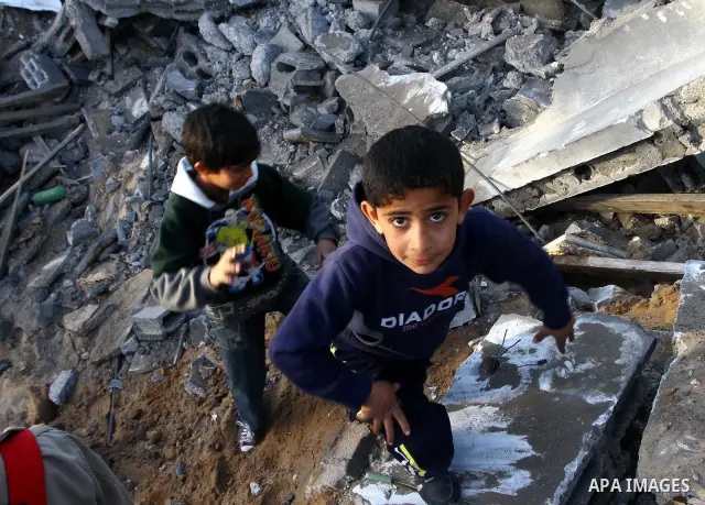 Palestinian onlookers gather at the scene of an Israeli air strike in the al-Burij refugee camp in the central Gaza Strip on February 26, 2011. Israeli warplanes bombed two training camps of the hardline Islamic Jihad gr...