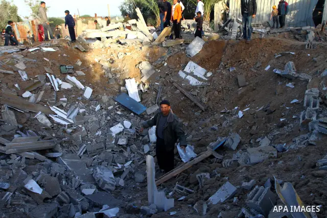 Palestinian onlookers gather at the scene of an Israeli air strike in the al-Burij refugee camp in the central Gaza Strip on February 26, 2011. Israeli warplanes bombed two training camps of the hardline Islamic Jihad gr...