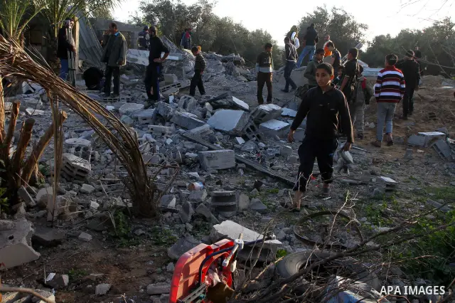 Palestinian onlookers gather at the scene of an Israeli air strike in the al-Burij refugee camp in the central Gaza Strip on February 26, 2011. Israeli warplanes bombed two training camps of the hardline Islamic Jihad gr...