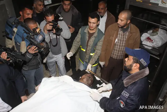 Palestinians gather around the body of a man at the mortuary of Al-Shifa hospital in Gaza City on February 27, 2011 after he was killed when an Israeli tank opened fire on a group of militants, medical sources and witnes...