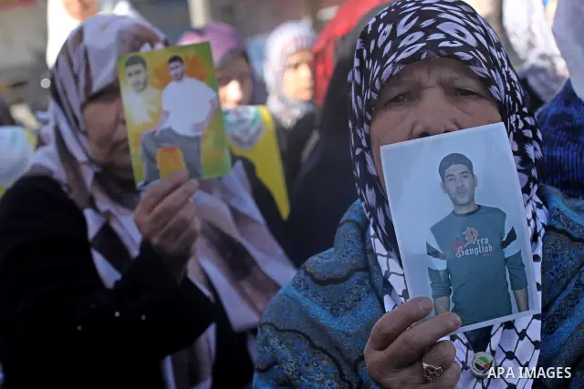 Palestinian women hold pictures of jailed relatives during a protest calling for the release of Palestinian prisoners from Israeli jails at the Red Cross office in Gaza City on Feb. 28, 2011. Photo by Mohammed Asad