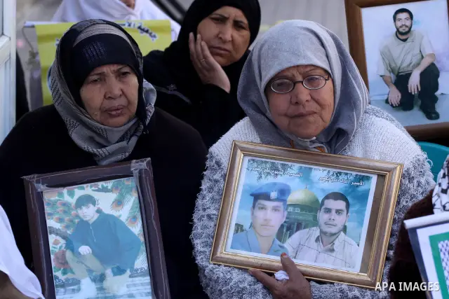 Palestinian women hold pictures of jailed relatives during a protest calling for the release of Palestinian prisoners from Israeli jails at the Red Cross office in Gaza City on Feb. 28, 2011. Photo by Mohammed Asad