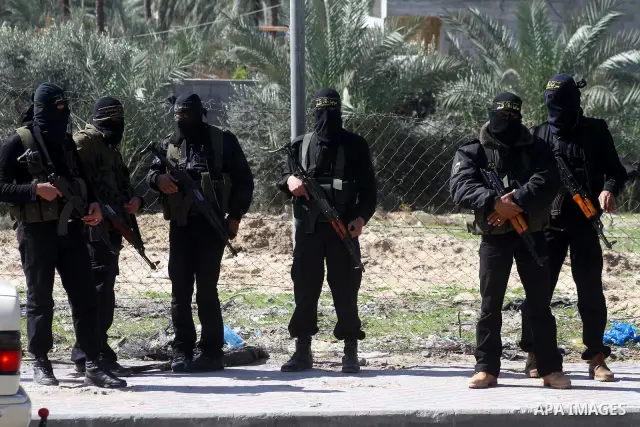 Masked Islamic Jihad militants wait next to the family house of Abeed Shaheen, killed by Israeli shell on Sunday, in Deir al-Balah refugee camp, central Gaza Strip, Monday, Feb. 28, 2011. Photo by Ashraf Amra