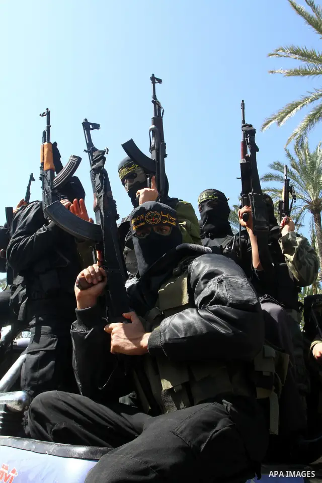 Masked Islamic Jihad militants wait next to the family house of Abeed Shaheen, killed by Israeli shell on Sunday, in Deir al-Balah refugee camp, central Gaza Strip, Monday, Feb. 28, 2011. Photo by Ashraf Amra