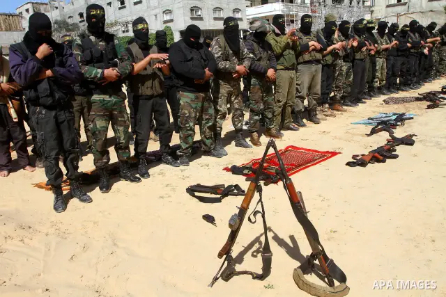 Masked Islamic Jihad militants wait next to the family house of Abeed Shaheen, killed by Israeli shell on Sunday, in Deir al-Balah refugee camp, central Gaza Strip, Monday, Feb. 28, 2011. Photo by Ashraf Amra