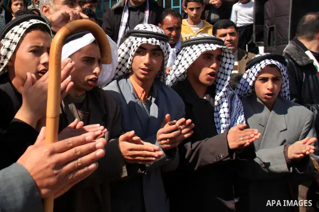 A Palestinian farmers celebrate after planting olive trees during a protest against the uprooting of trees belonging to Palestinians by Jewish settlers near the settlement of Elon Moreh in the West Bank village of Deir a...
