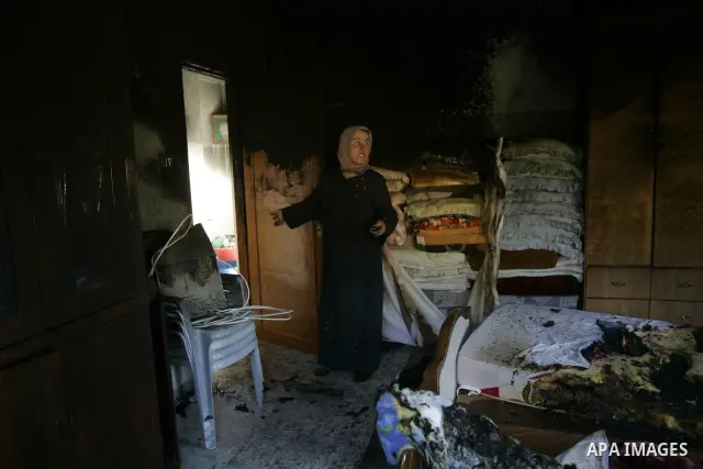 A Palestinian woman looks at a burnt room after her family house was firebombed by Jewish settlers overnight in the West Bank village of Huwwara near Nablus, on March 01, 2011 causing two children to be taken to hospital...
