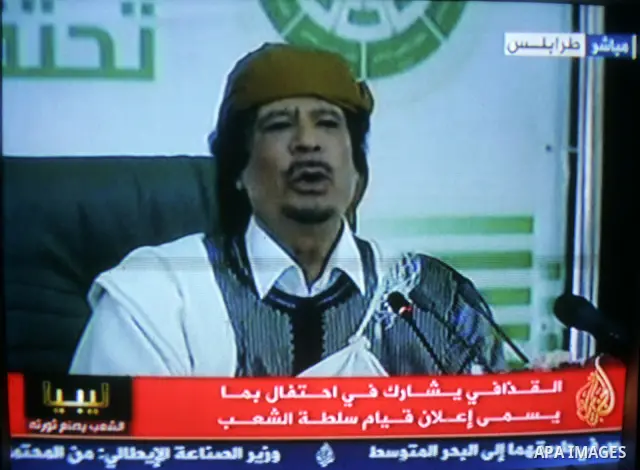 A picture taken from Qatar Al Jazeera state television on March 02, 2011 shows Libyan leader Moammar Qadhafi addressing to the loyalists of his regime during a public rally in Tripoli, as rebels fought back his forces ea...