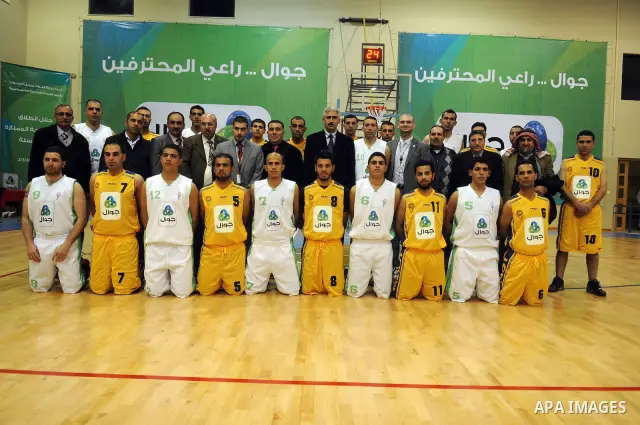 Palestinian basketball players pose for photographs after a basketball game between Abdaa team and Alfaraa team during opening of Premier League for basketball, in the West Bank City of Bethlehem on March 02, 2011. Photo...