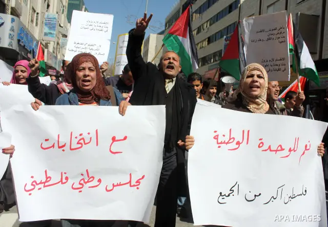 Palestinian protestors hold national flags and banners during a rally against the U.S. veto and calling for the national reconciliation, in the West Bank city of Hebron, on March 03, 2011. Photo by Najeh Hashlamoun