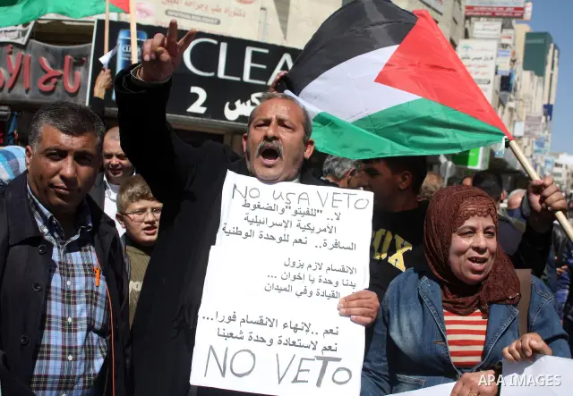 Palestinian protestors hold national flags and banners during a rally against the U.S. veto and calling for the national reconciliation, in the West Bank city of Hebron, on March 03, 2011. Photo by Najeh Hashlamoun