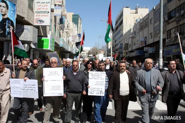 Palestinian protestors hold national flags and banners during a rally against the U.S. veto and calling for the national reconciliation, in the West Bank city of Hebron, on March 03, 2011. Photo by Najeh Hashlamoun