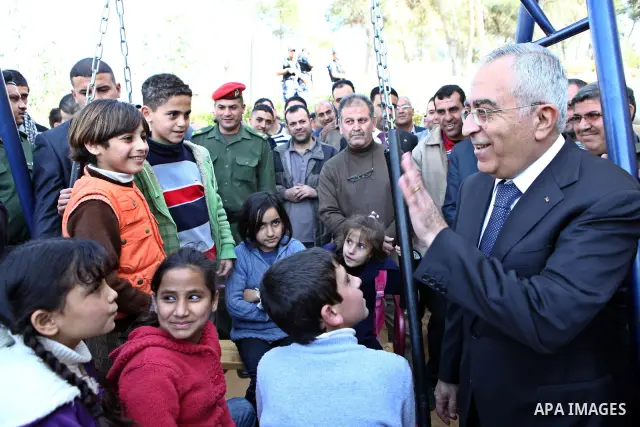 Palestinian Prime Minister Salam Fayyad, waves to the children during the opening of the vocational rehabilitation centre for the Deaf in Village of Nabi Elias, in the West Bank city of Qalqilya on March 3, 2011. Photo b...
