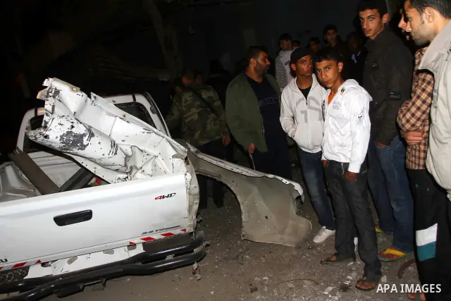 Palestinians inspect a car damaged by an Israeli airstrike, in the central Gaza Strip, March 4, 2011. Palestinian official said that Israeli aircraft struck a car on Friday with no injures.. Photo by Ashraf Amra