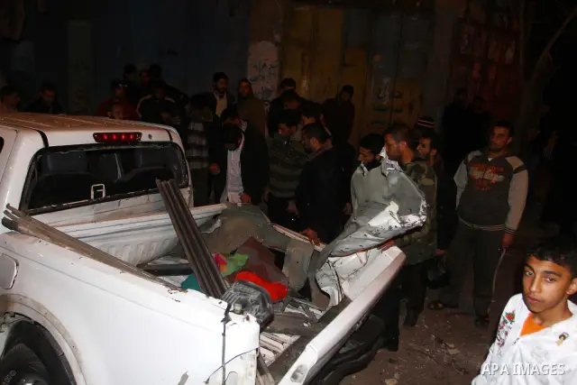Palestinians inspect a car damaged by an Israeli airstrike, in the central Gaza Strip, March 4, 2011. Palestinian official said that Israeli aircraft struck a car on Friday with no injures.. Photo by Ashraf Amra