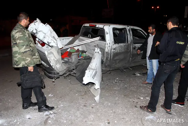 Palestinians inspect a car damaged by an Israeli airstrike, in the central Gaza Strip, March 4, 2011. Palestinian official said that Israeli aircraft struck a car on Friday with no injures.. Photo by Ashraf Amra