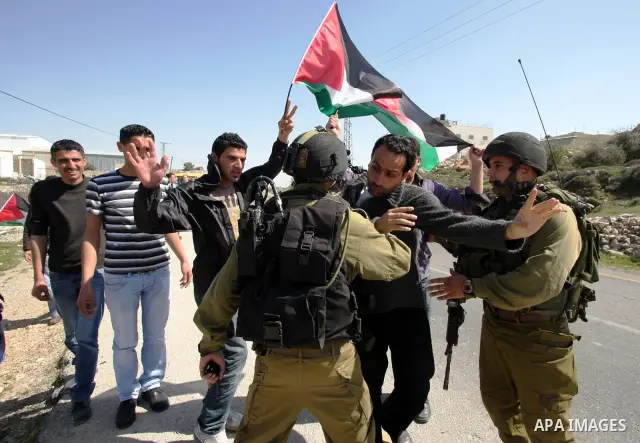 Protesters argue with an Israeli soldier during a demonstration against Israel's controversial separation barrier in the West Bank village of Maasarah, near the biblical town of Bethlehem on March 04, 2011.Israel says th...