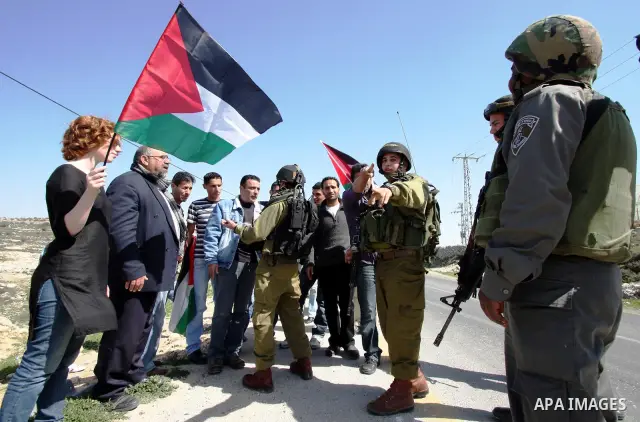 Protesters argue with an Israeli soldier during a demonstration against Israel's controversial separation barrier in the West Bank village of Maasarah, near the biblical town of Bethlehem on March 04, 2011.Israel says th...