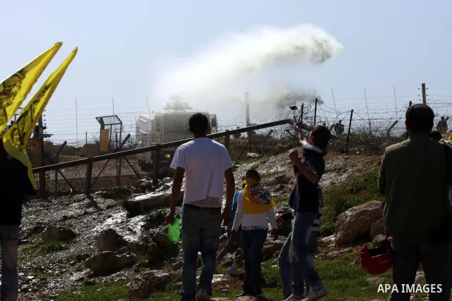 A Palestinian youth hurls a stone at Israeli soldiers during a protest against Israel's controversial separation barrier in the village of Bilin, near the West Bank city of Ramallah, in the Israeli occupied West Bank, on...