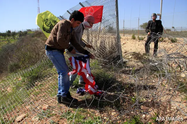 A Palestinian protester burns a U.S. flag during a protest against the construction of Israel's separation barrier in the West Bank village of Bilin near Ramallah, Friday,March 4, 2011. Photo by Wagdi Eshtayah