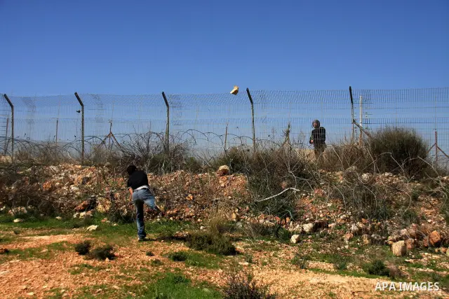 A Palestinian demonstrator hurls stones at Israeli troops during a protest against the construction of Israel's separation barrier in the West Bank village of Bilin near Ramallah, Friday,March 4, 2011. Photo by Wagdi Esh...