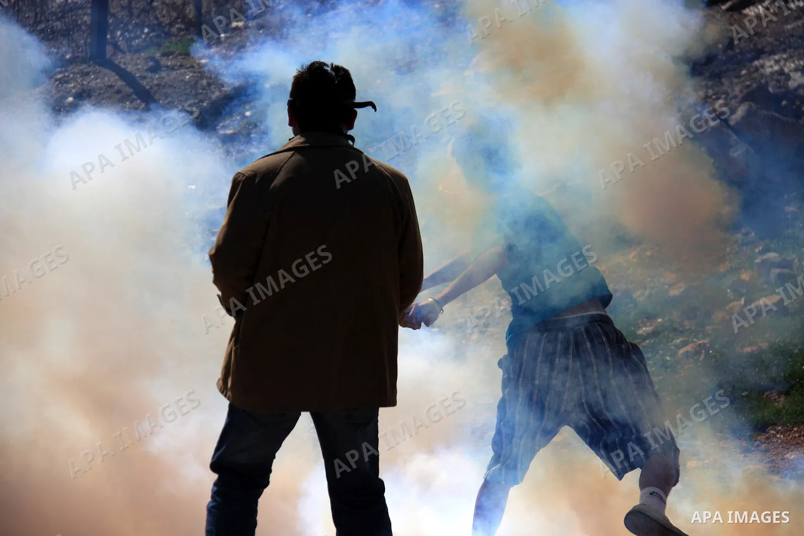 Palestinians, Israelis and foreign demonstrators run from tear gas fired by Israeli troops during a protest against the construction of Israel's separation barrier in the West Bank village of Bilin near Ramallah, Friday,...