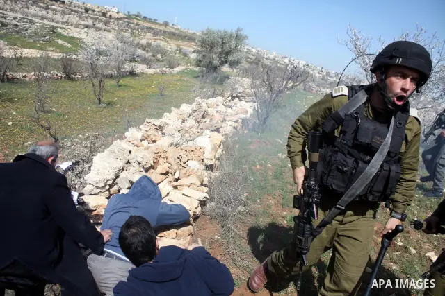 Israeli soldiers throw a stun grenade and fire tear gas towards Palestinian ,Israelian and International protesters during a demonstration against the demolishing of farm land to be used in the construction of Jewish set...