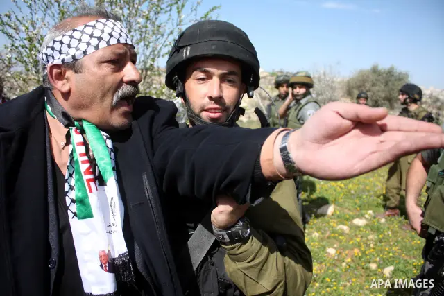 Israeli soldiers throw a stun grenade and fire tear gas towards Palestinian ,Israelian and International protesters during a demonstration against the demolishing of farm land to be used in the construction of Jewish set...