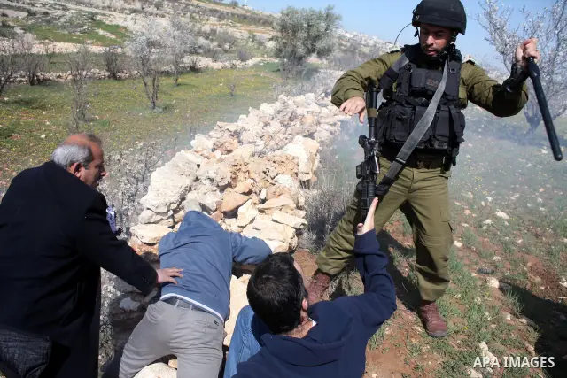 Israeli soldiers throw a stun grenade and fire tear gas towards Palestinian ,Israelian and International protesters during a demonstration against the demolishing of farm land to be used in the construction of Jewish set...