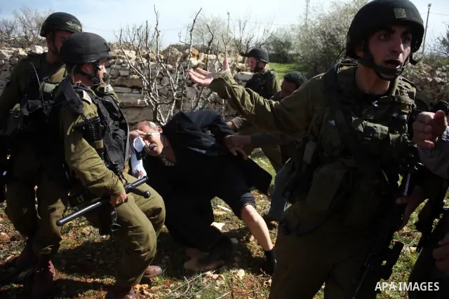 Israeli soldiers throw a stun grenade and fire tear gas towards Palestinian ,Israelian and International protesters during a demonstration against the demolishing of farm land to be used in the construction of Jewish set...