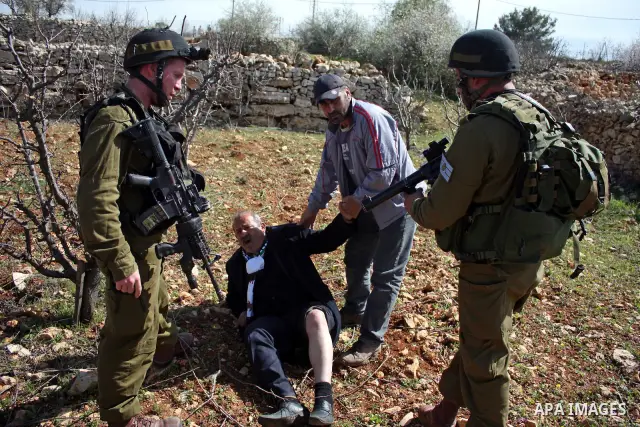 Israeli soldiers throw a stun grenade and fire tear gas towards Palestinian ,Israelian and International protesters during a demonstration against the demolishing of farm land to be used in the construction of Jewish set...
