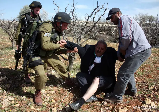 Israeli soldiers throw a stun grenade and fire tear gas towards Palestinian ,Israelian and International protesters during a demonstration against the demolishing of farm land to be used in the construction of Jewish set...