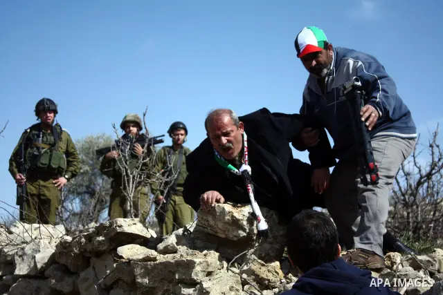 Israeli soldiers throw a stun grenade and fire tear gas towards Palestinian ,Israelian and International protesters during a demonstration against the demolishing of farm land to be used in the construction of Jewish set...