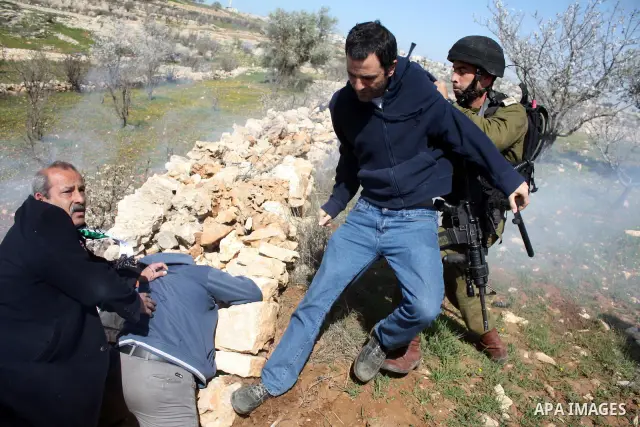 Israeli soldiers throw a stun grenade and fier tear gas towards Palestinian ,Israelian and International protesters during a demonstration against the demolishing of farm land to be used in the construction of Jewish set...