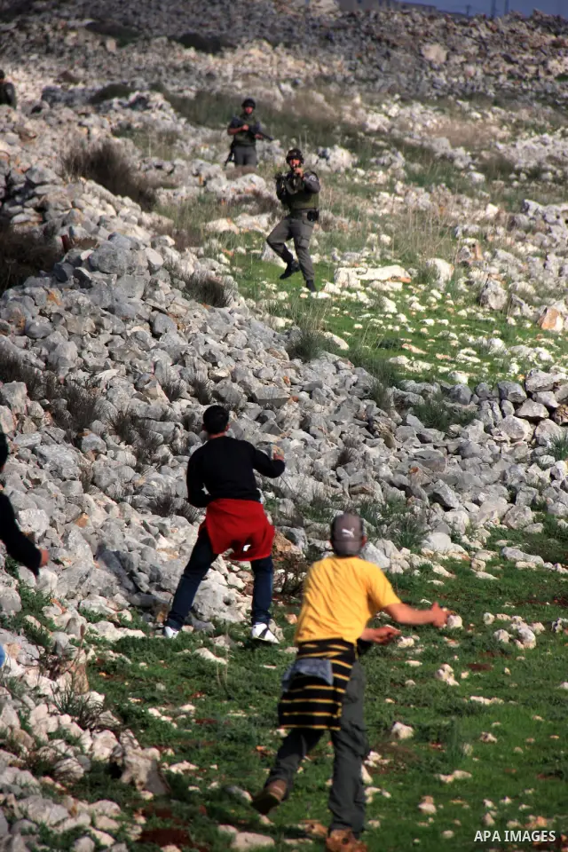 Palestinian protestors hurl stones at Israeli troops, in the West Bank village of Iraq Burin, near Nablus,Saturday , March 5, 2011... Photo by Wagdi Eshtayah