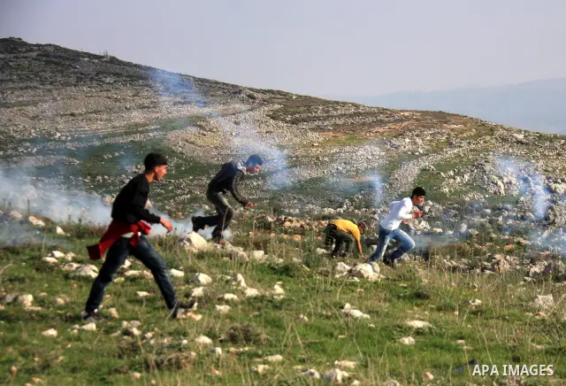 Palestinian demonstrators run to seek cover from tear gas fired by Israeli soldiers in the West Bank village of Iraq Borin near Nablus, on 05 March 2011. Two Palestinians were wounded after Israeli troops raided the vill...