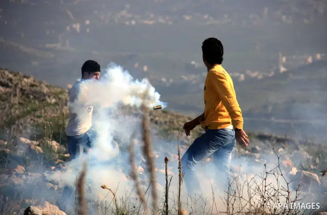Palestinian demonstrators run to seek cover from tear gas fired by Israeli soldiers in the West Bank village of Iraq Borin near Nablus, on 05 March 2011. Two Palestinians were wounded after Israeli troops raided the vill...