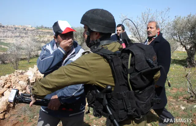 Israeli soldiers throw a stun grenade and fire tear gas towards Palestinian ,Israelian and International protesters during a demonstration against the demolishing of farm land to be used in the construction of Jewish set...