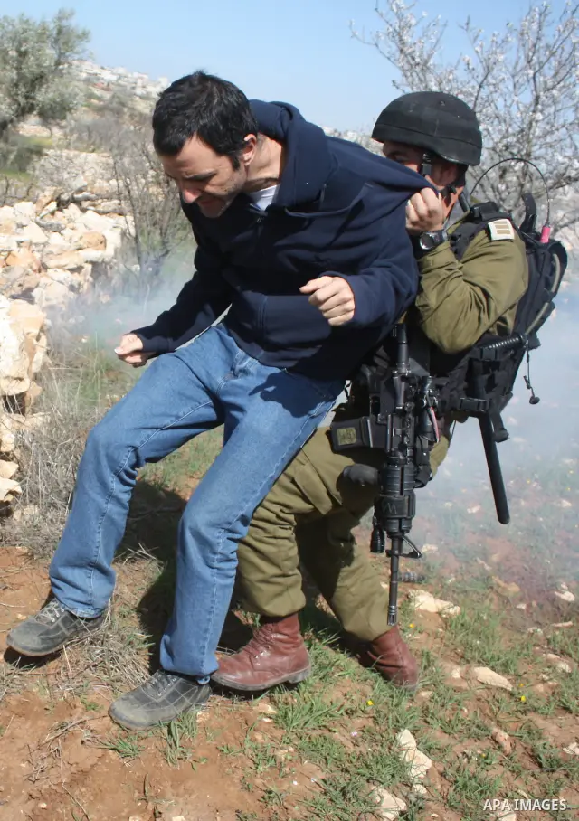 Israeli soldiers throw a stun grenade and fire tear gas towards Palestinian ,Israelian and International protesters during a demonstration against the demolishing of farm land to be used in the construction of Jewish set...