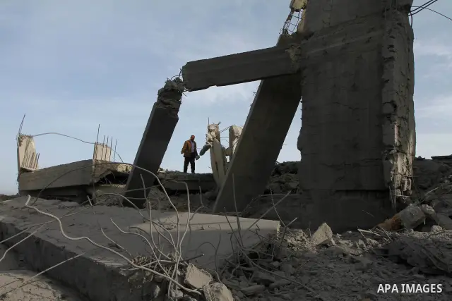 A Palestinian man inspects the damage to a building still under construction and belonging to the Islamic University, following an overnight Israeli air raid, south of Gaza City, on March 6, 2011. Photo by Ashraf Amra