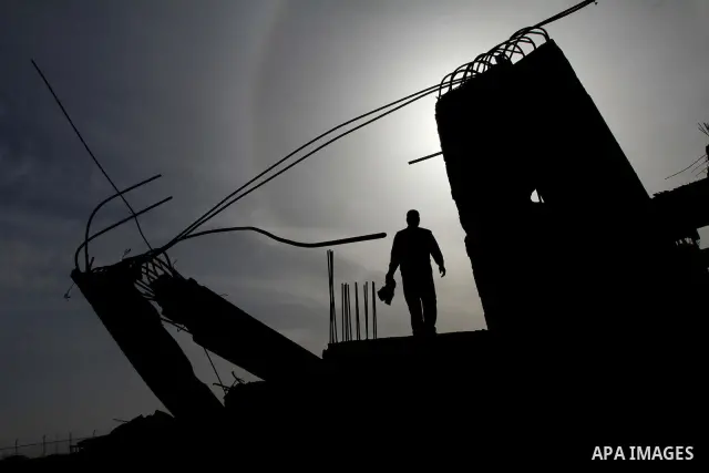 A Palestinian man inspects the damage to a building still under construction and belonging to the Islamic University, following an overnight Israeli air raid, south of Gaza City, on March 6, 2011. Photo by Ashraf Amra